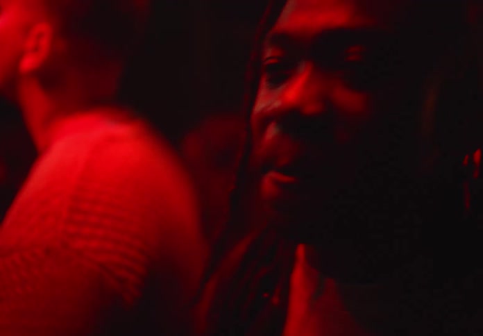 People enjoy themselves while dancing in a dim room lit by colored lighting