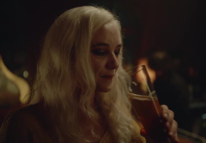 Happy woman drinking a glass of beer