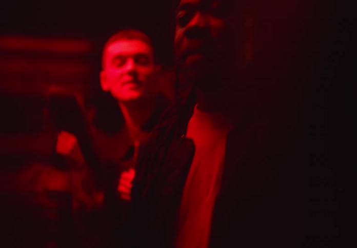 A man dancing and talking on a packed night club
