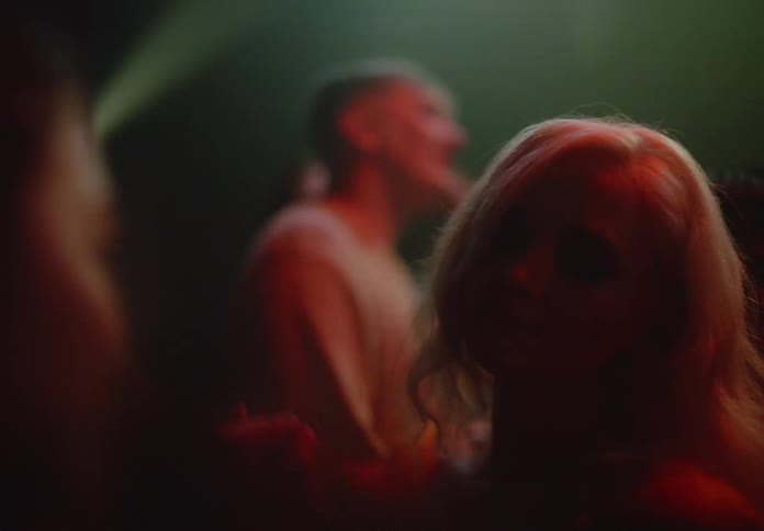 Blonde woman dancing in a club with other people