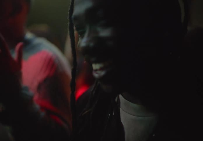 Close up of a man with long braided hair dancing in a nightclub