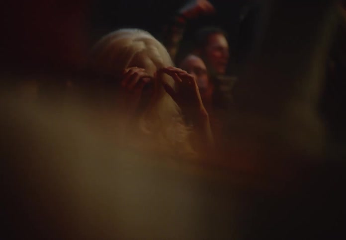 Blonde woman dancing having fun in a crowd