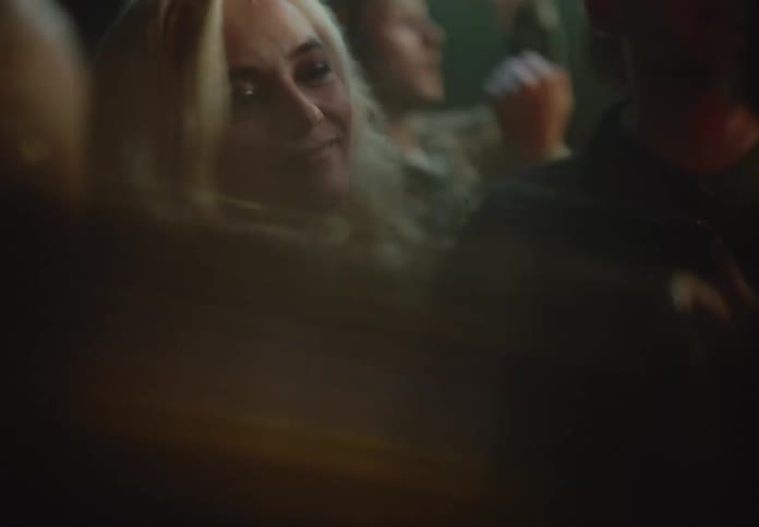 Blonde woman dancing with other people at a nightclub