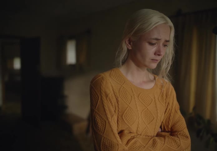 Blonde woman with arms crossed crying