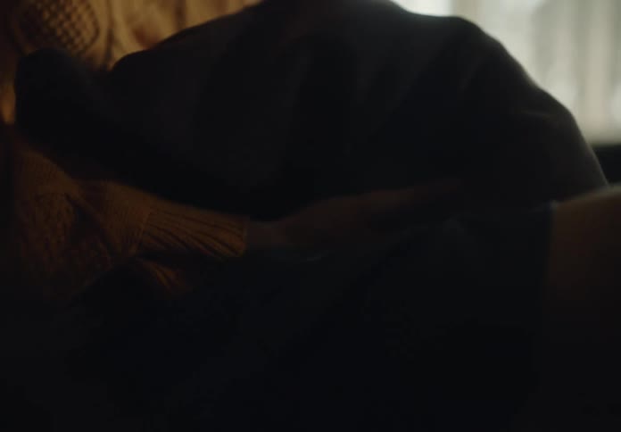 Pair of hands of an apprehensive woman holding a sweatshirt