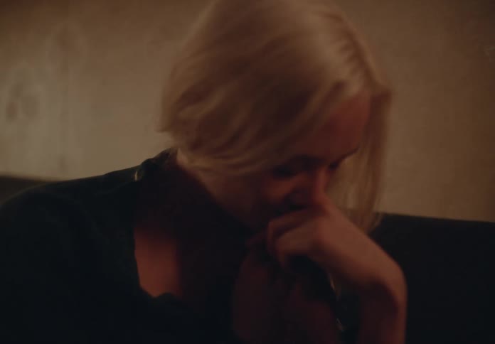 Woman cuddles hand of man against herself and smiles