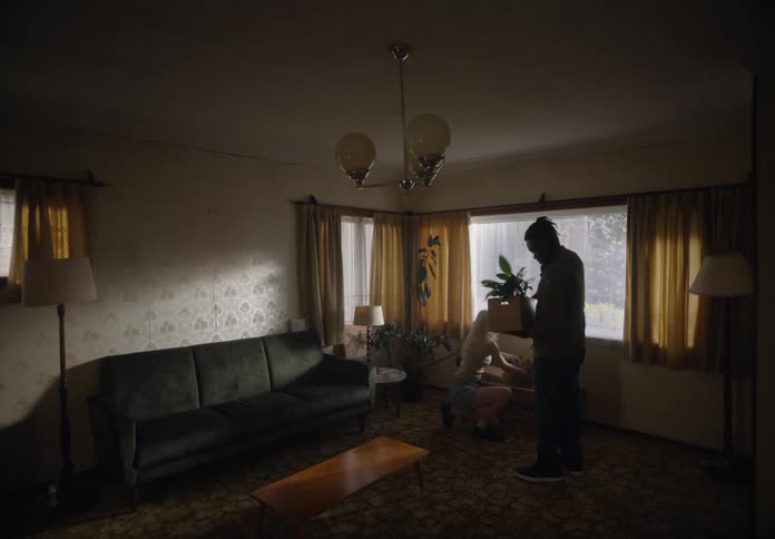 Man and a woman in a living room arranging furniture