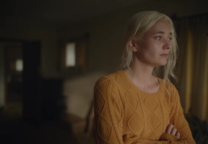 Blonde woman in living room with sad facial expression