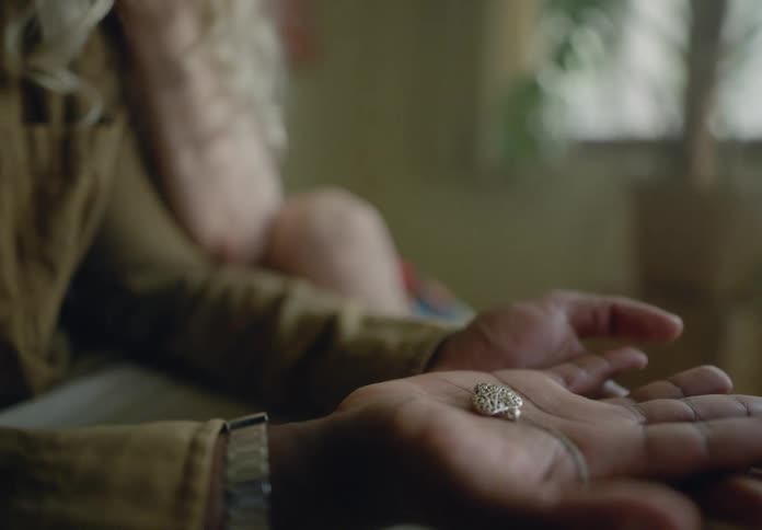 Close up of a persons hands with an earring