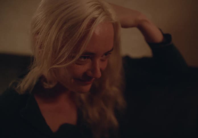 Portrait of a blonde woman with a crying expression and someone elses hand running through her hair