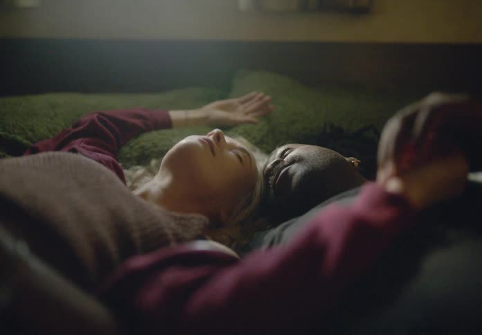 Couple lying hands together in bed