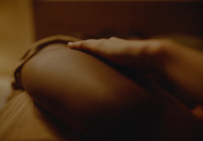 Woman lying in bed next to a man caressing him