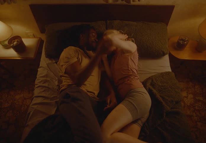 A man and woman cuddle in bed