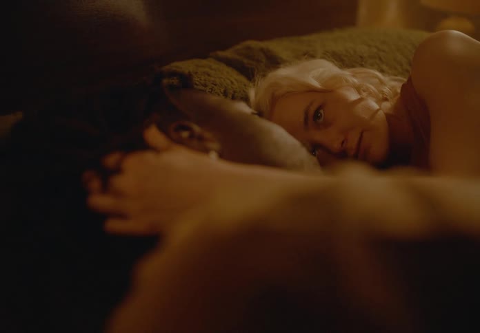 A young couple cuddling together in bed in a cozy bedroom