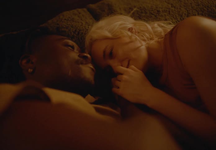 Couple lying together hugging and happy in bed