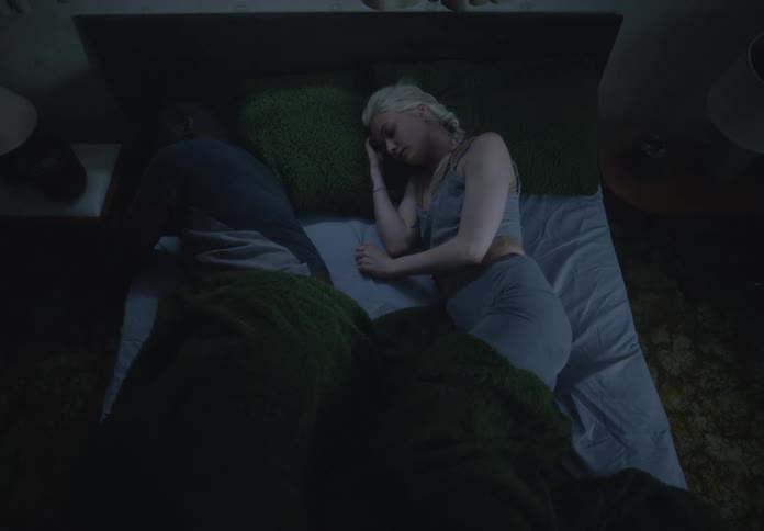 A couple in bed with the woman trying to hug the man who turns away causing her to feel sad and also turn away