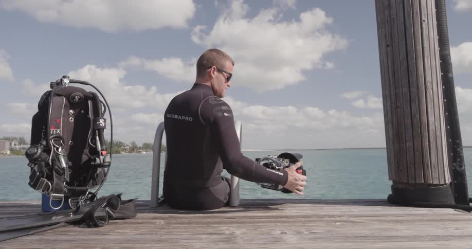 Man looks at his camera near a body of water