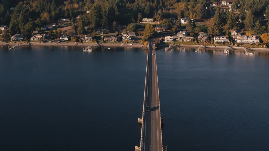 Long bridge giving access to an urban city in wooded hills