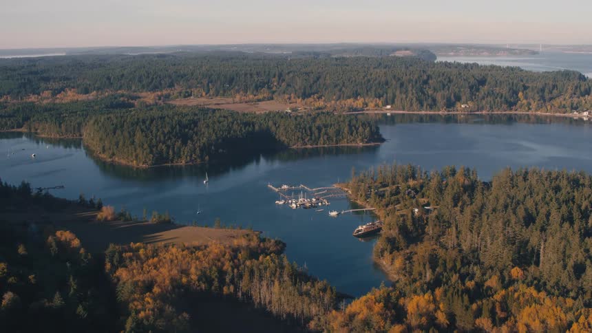 Aerial landscape of long stretches of land with forests surrounded by a river