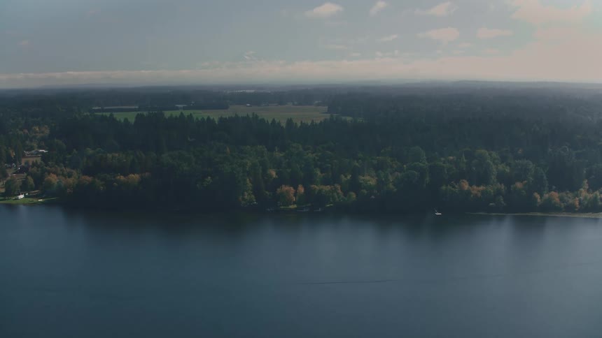 Aerial landscape of a river surrounded by fields with forests