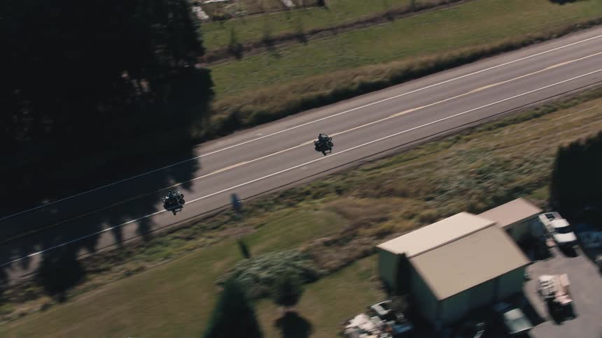 Aerial view of two motorcycles traveling on a paved road