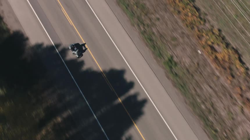 Aerial view of a person on a motorcycle traveling along a highway