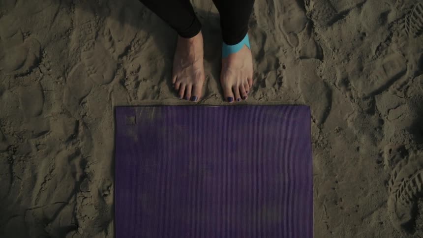 woman standing at yoga mat