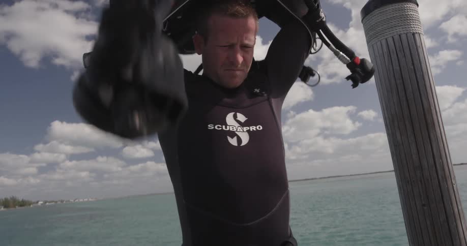 A diver puts n his scuba tank