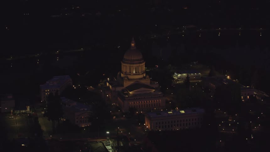 Aerial view of a classical building surrounded by other buildings seen at night