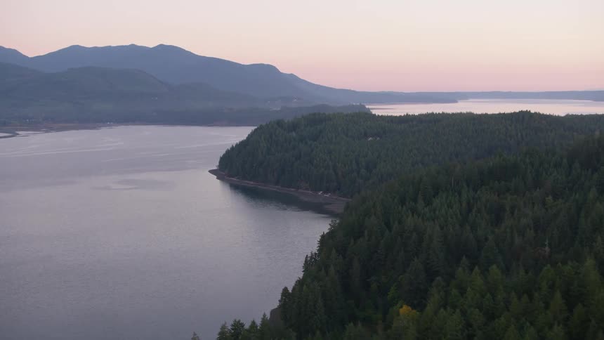 Aerial panorama of forested mountains by the sea