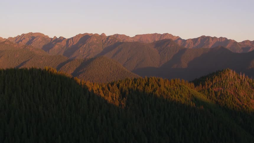 Aerial landscape of forested mountain ranges at dawn