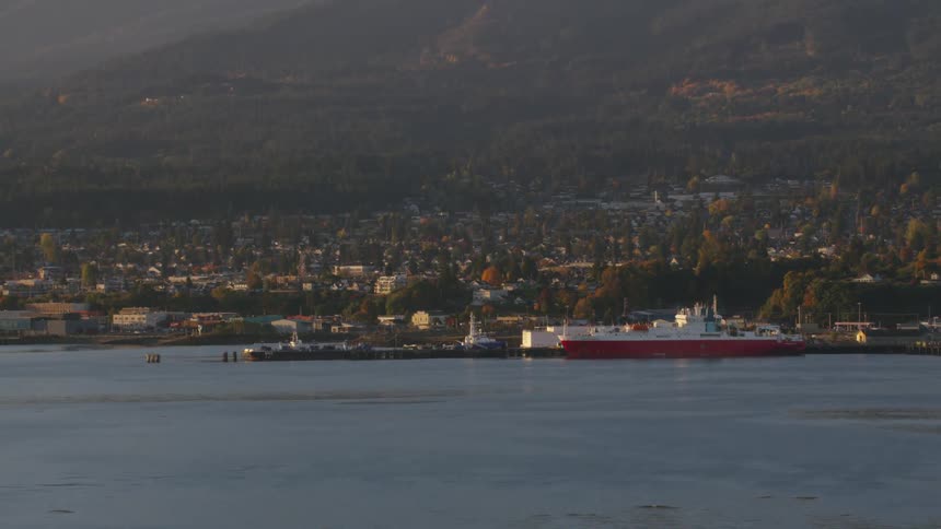 Aerial view of a ship in a port with a city in the background