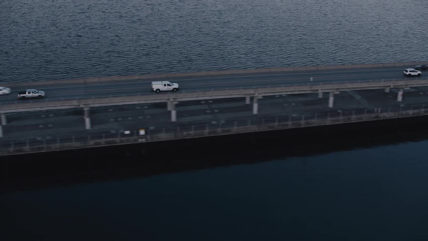 Aerial view of a bridge crossing the sea with vehicle traffic