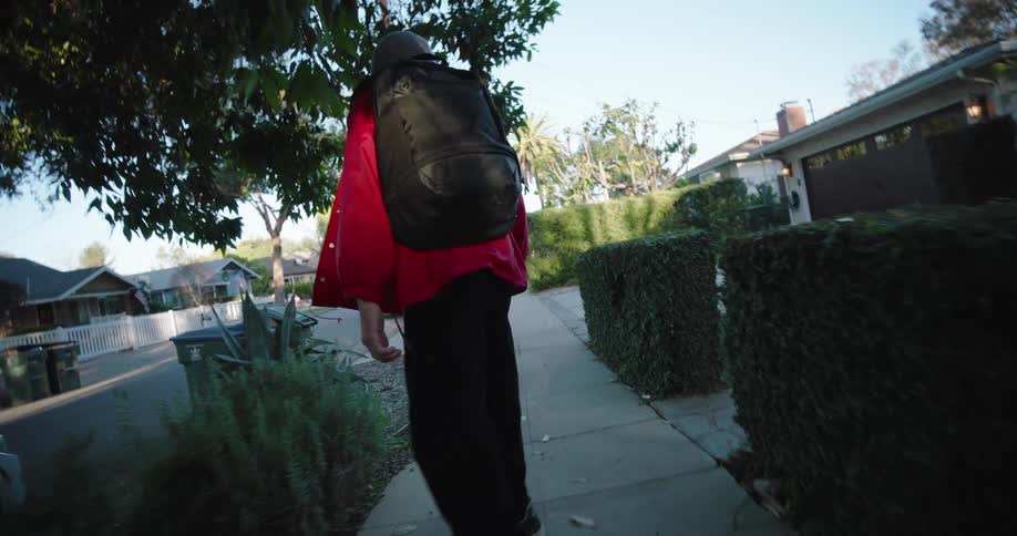 A child is skateboarding on the sidewalk