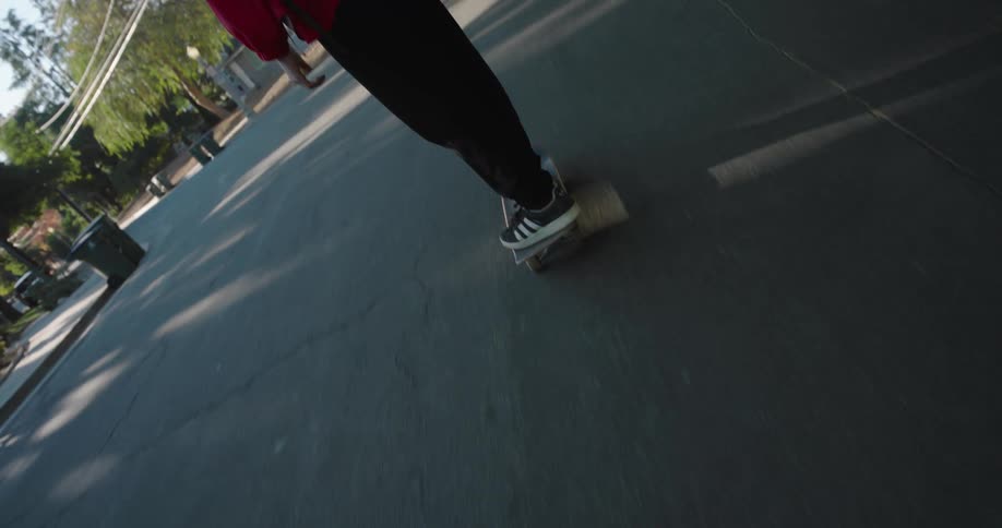 A boy is skateboarding around the turn of the road