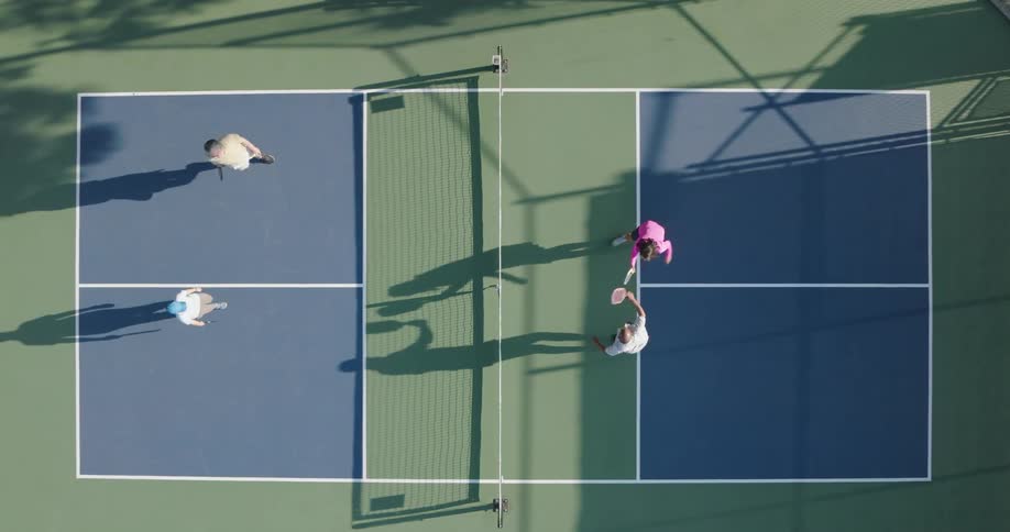 Aerial of two couples playing pickleball in an outdoor court