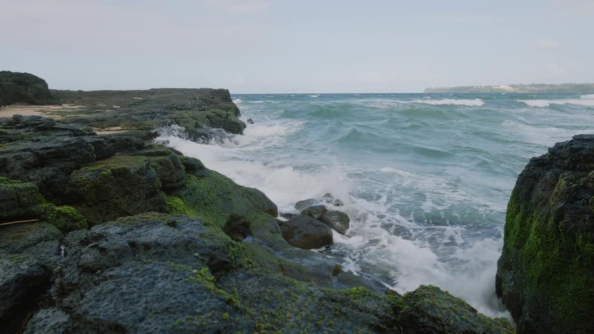 Rough ocean waters crashing against rocks in the foreground