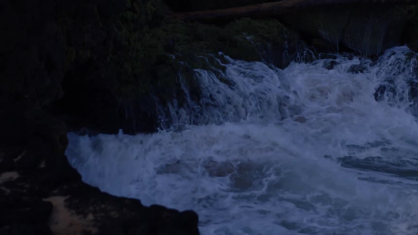 A sea wave hitting rocks on a coast and making several splashes