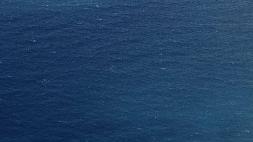 The deep blue ocean stretches out in rippled waves