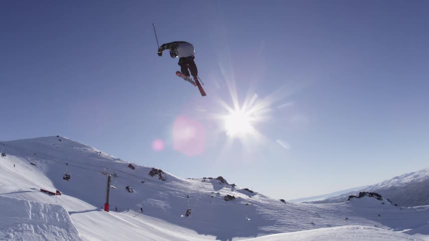A skier jumps over a snow ramp