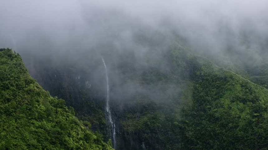 A fog is hanging over a small waterfall on the mountain