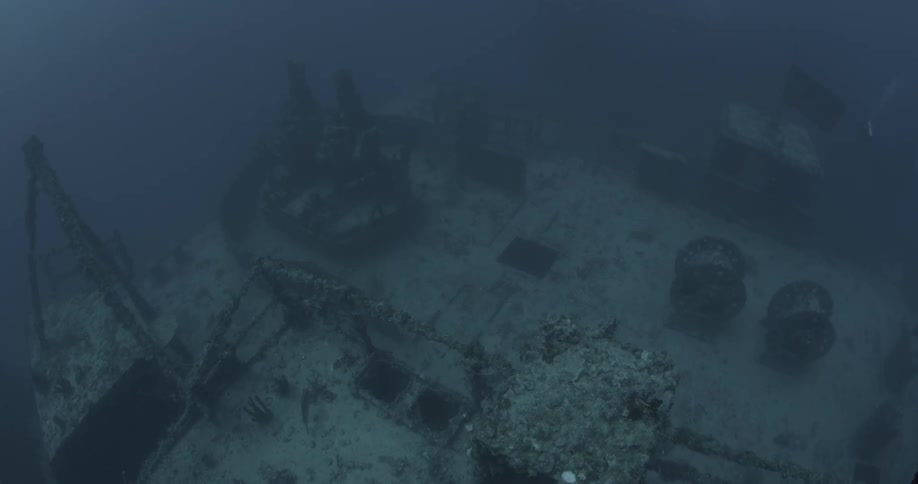 An old wreck covered in sediment is lying on the ocean floor