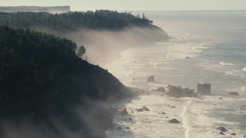 Waves crash against the hills on the shore