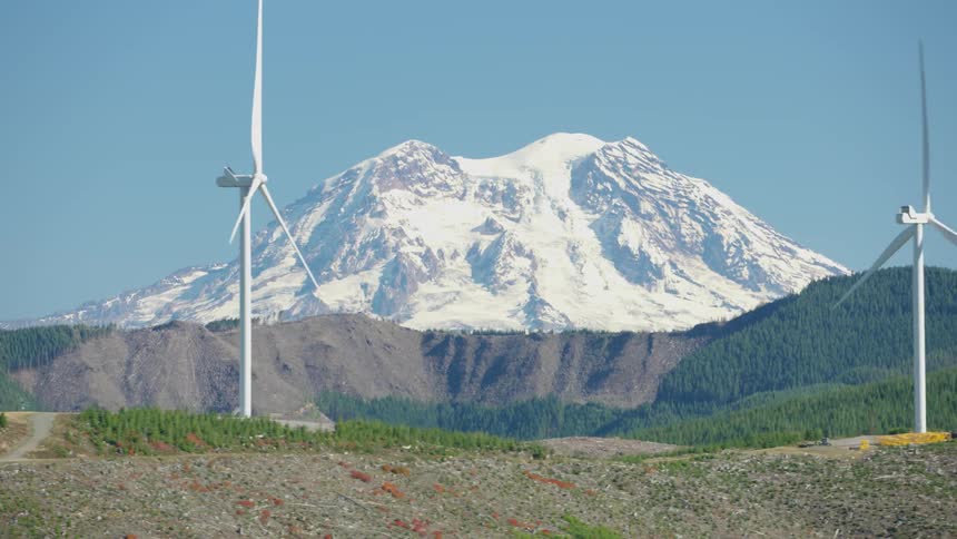 Wind power engines in operation and a snowy mountain in the background