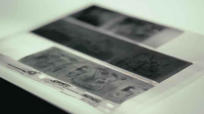 Black and white photographs on a plastic sheet on a white table