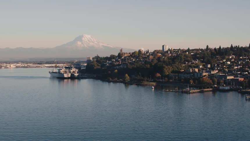 Urban seaside city with a snowy mountain peak on the horizon