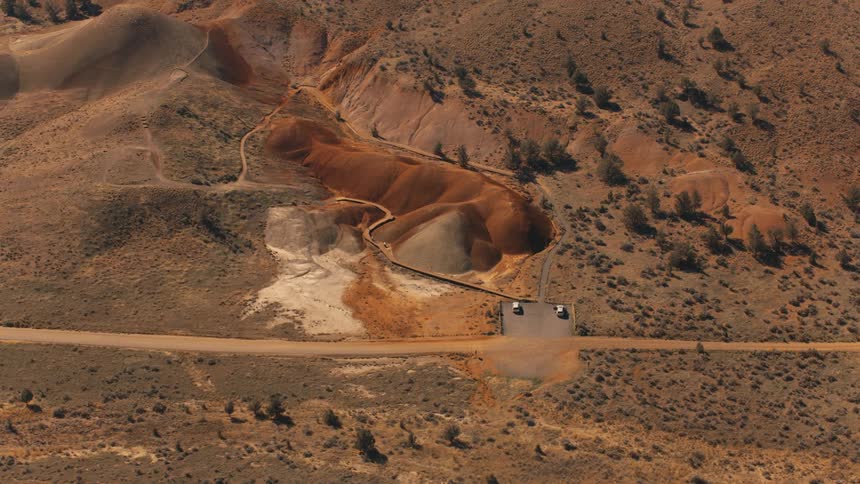 Aerial panorama of a barren mountain with winding trail paths