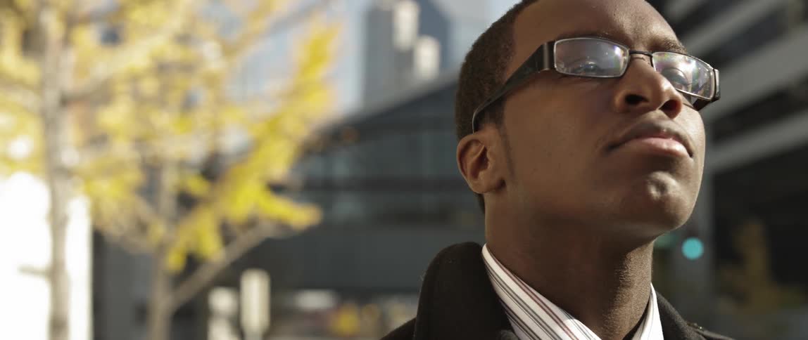 A man looks upwards in a city