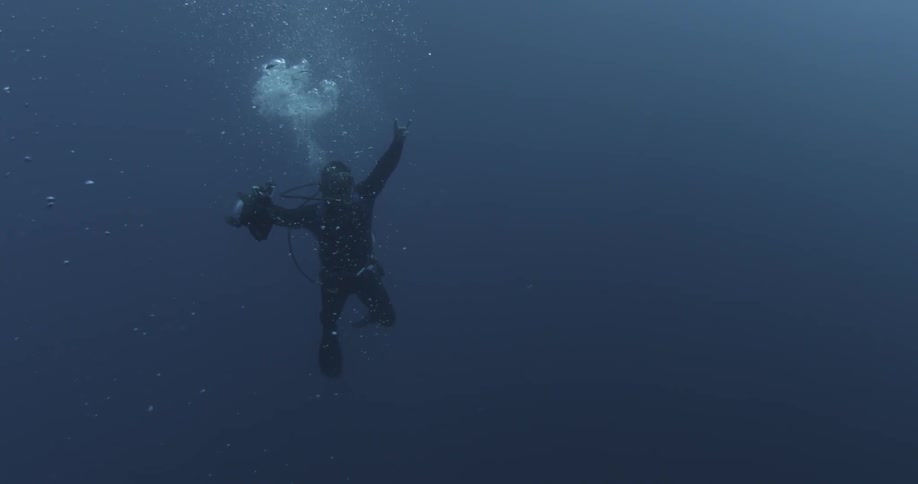 A diver is holding a camera underwater