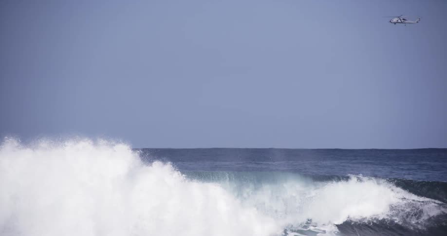 A wave is breaking as a surfer rides he